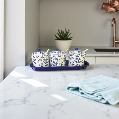 A three-piece set of blue and white leaf-patterned ceramic seasoning jars with a blue tray A three-piece set of blue and white leaf-patterned ceramic seasoning jars with a blue tray